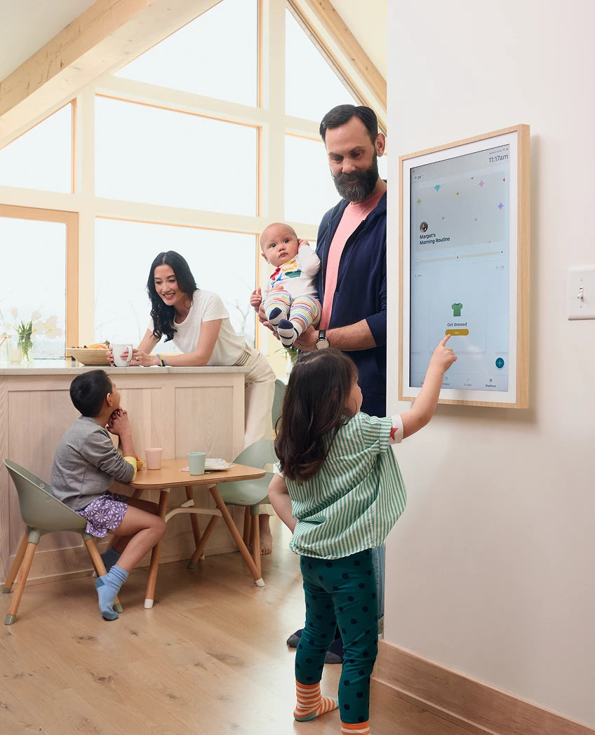 Family in a modern home with a child interacting with a digital display.